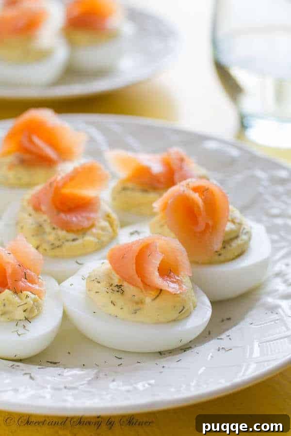 A beautifully arranged plate of smoked salmon deviled eggs, garnished with fresh dill, making an elegant and flavorful side for any ham dinner.