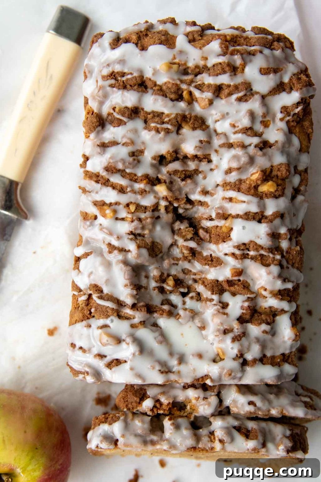 Cozy Gluten-Free Apple Cinnamon Crumble Bread 2 overhead shot of gluten free apple bread with glaze drizzled over top, showcasing its golden crust and delicious streusel