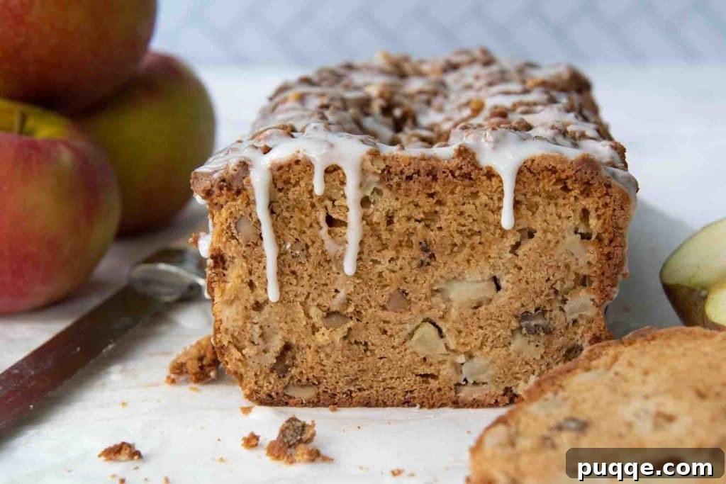 Cozy Gluten-Free Apple Cinnamon Crumble Bread 7 a beautifully baked apple bread, freshly cut, with vanilla glaze dripping down, surrounded by crisp apples