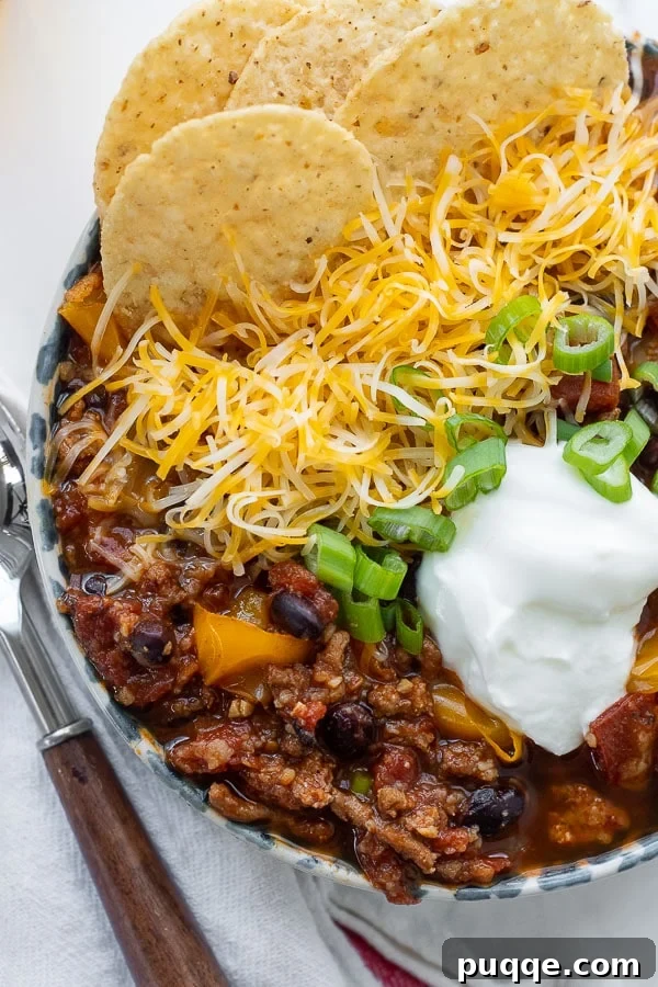 Close-up overhead shot of turkey chili in a bowl with various toppings