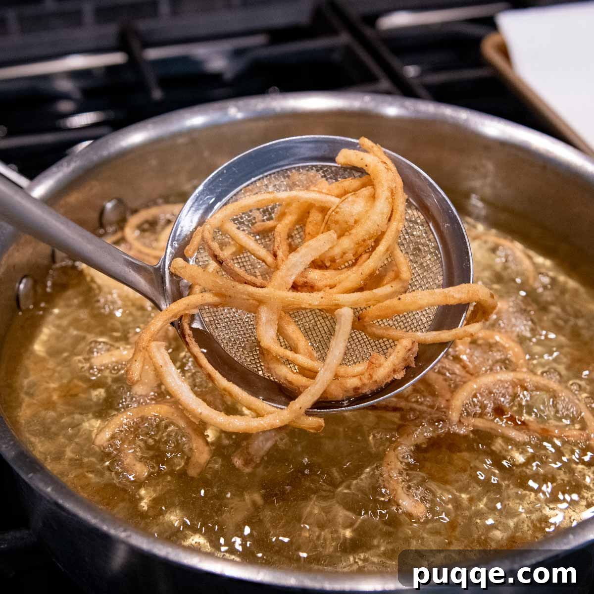 Hearty Homestyle Gluten-Free Green Bean Bake 3 Crispy gluten-free french fried onions being removed from hot oil.
