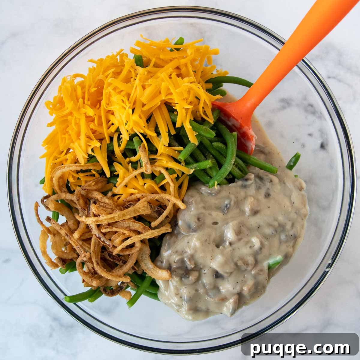 Hearty Homestyle Gluten-Free Green Bean Bake 5 All the casserole ingredients, including green beans, sauce, and onions, mixed in a large glass bowl.