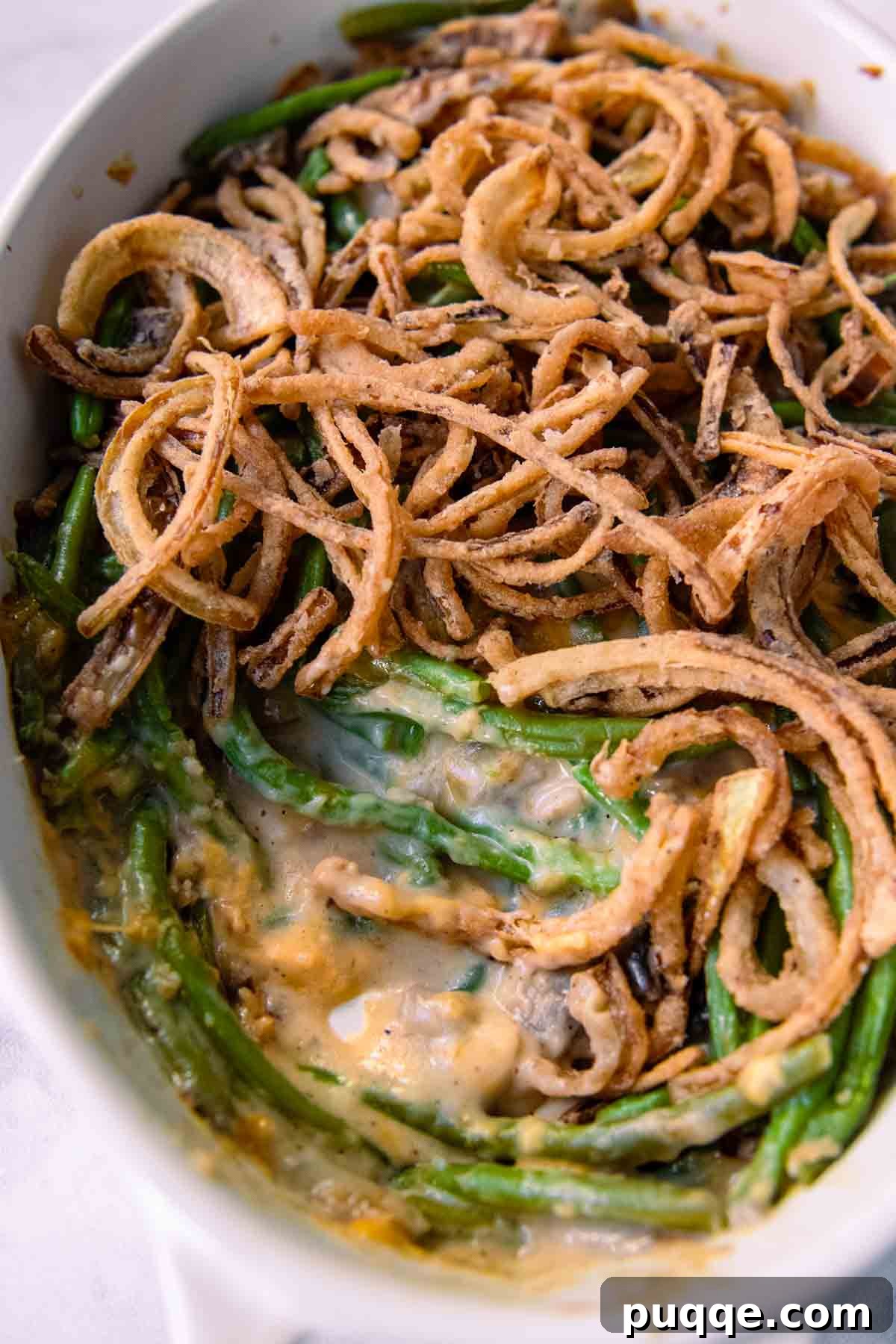 Hearty Homestyle Gluten-Free Green Bean Bake 8 Close-up of the inside of a gluten-free green bean casserole, showing its creamy texture and fried onions on top.