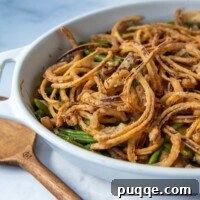 a close up shot of gluten free green bean casserole on a marble surface