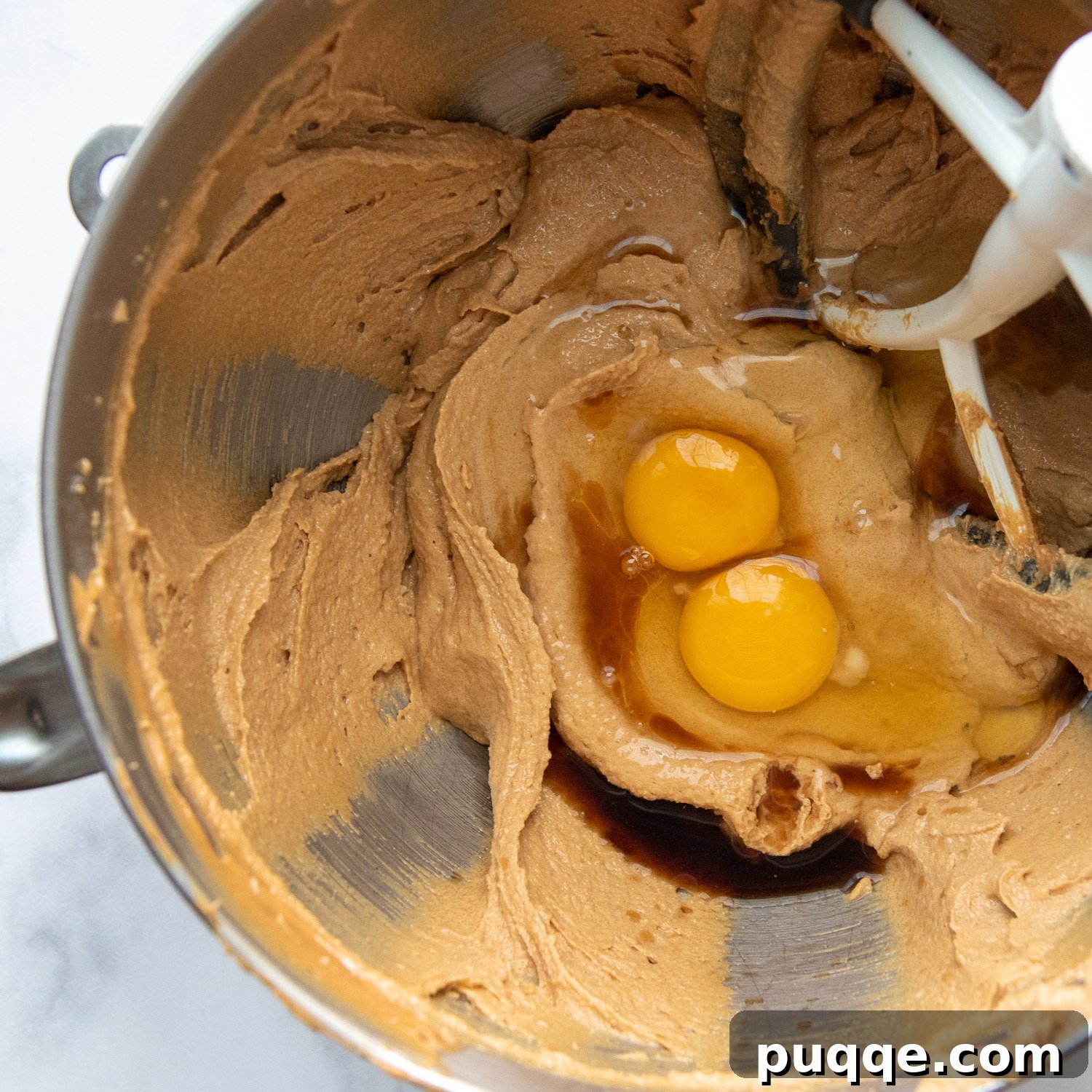 Pillowy Soft Flourless Gluten-Free Monster Cookies 3 The creamy mixture of butter, peanut butter, and sugars in a bowl, with eggs and vanilla just added, ready to be mixed.