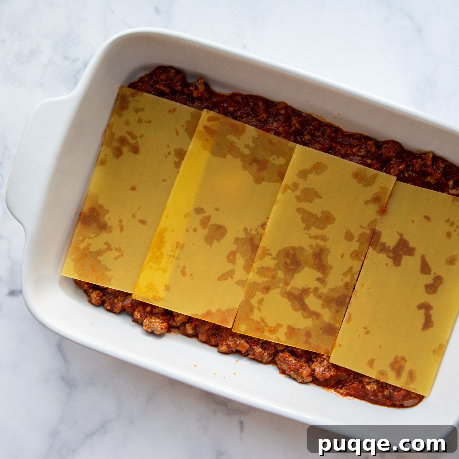 A perfectly layered lasagna, showing the even distribution of noodles, ricotta, and sauce before baking.