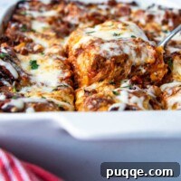 A beautifully presented slice of gluten-free lasagna being lifted from a white baking dish, showcasing its perfectly cooked layers.