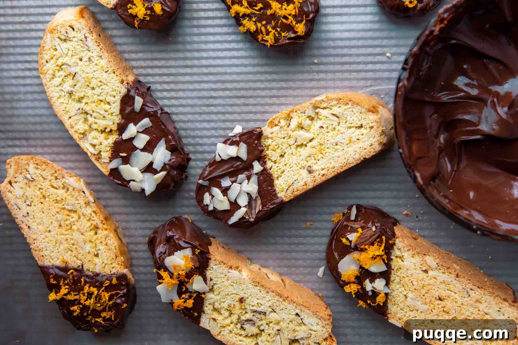 Feather-Light, Perfectly Crispy Gluten-Free Biscotti 7 An inviting overhead shot showcasing a baking sheet generously filled with an assortment of homemade biscotti, some elegantly dipped in chocolate and others awaiting their decorative finish.