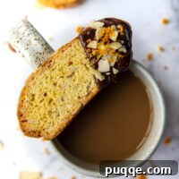 Feather-Light, Perfectly Crispy Gluten-Free Biscotti 9 a gluten-free biscotti dipped in chocolate resting on top of a coffee cup