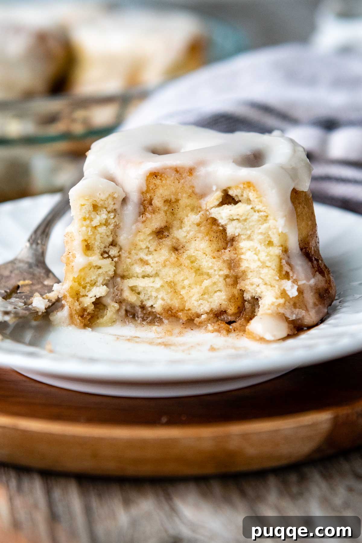 5 Easy Tricks for Perfect Gluten-Free Baking 3 a cinnamon bun with a bite taken out on a white plate.