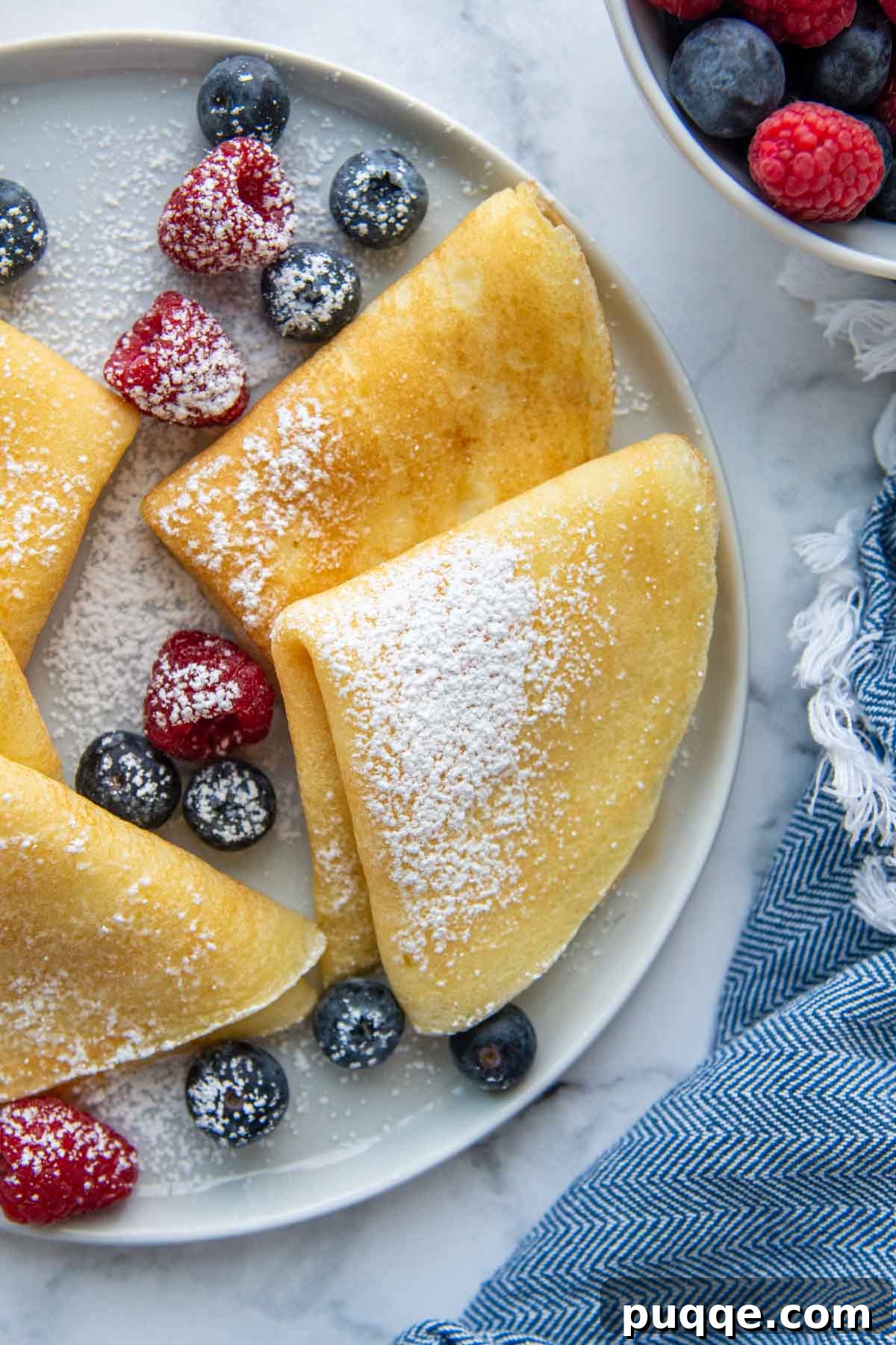 overhead view of folded gluten-free crepes on a white plate