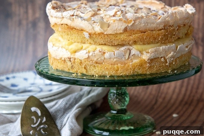 The entire unsliced Blitz Torte resting on a elegant green cake stand, ready to be presented.