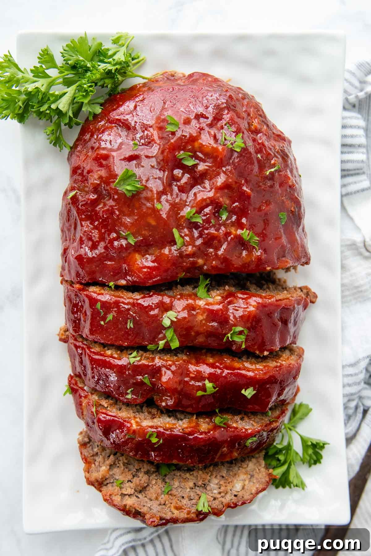 Juicy Gluten-Free Meatloaf: A Taste of Home Comfort 7 An inviting overhead shot of perfectly sliced gluten-free meatloaf on a white plate, ready to be served, highlighting its tender texture.