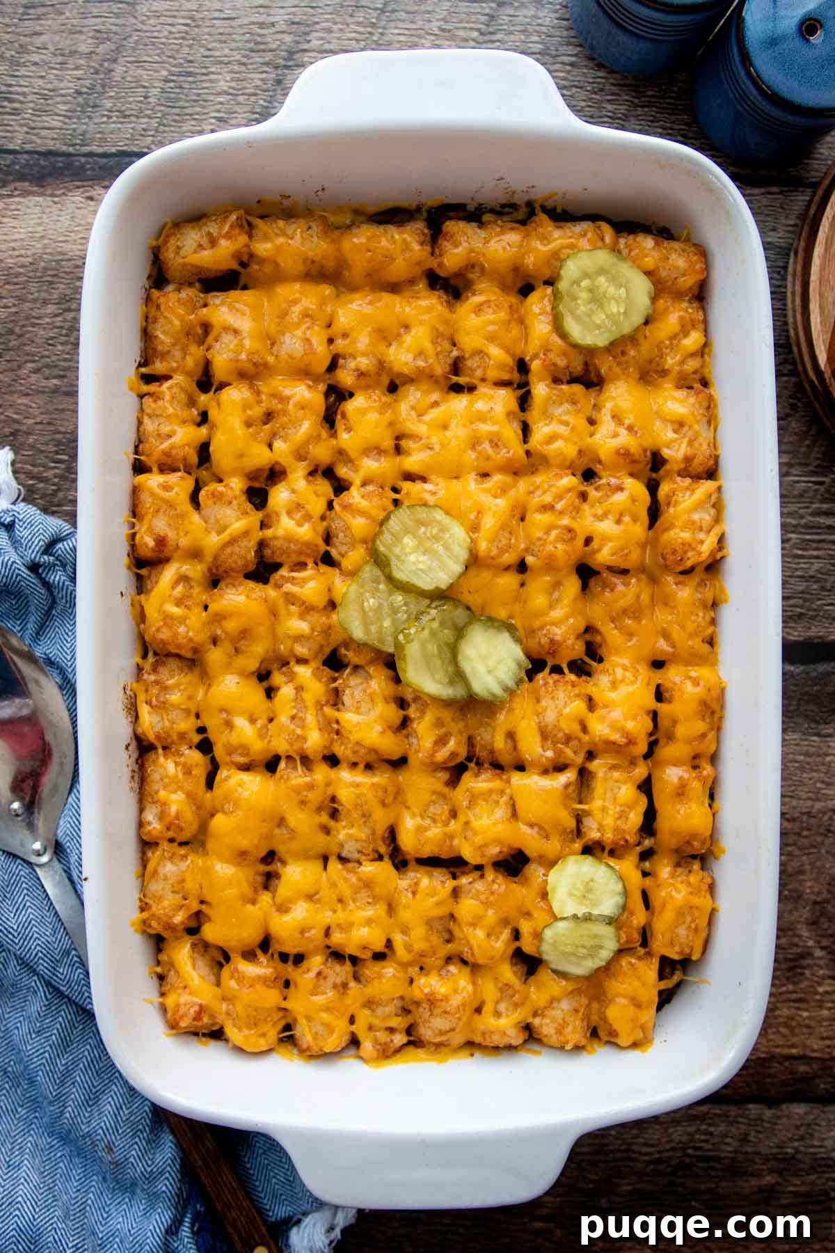 Golden Tater Tot Sloppy Joe Bake 8 An inviting overhead shot of the baked Sloppy Joe Tater Tot Casserole, garnished with sliced pickles, highlighting the bubbly cheese and crispy tots.