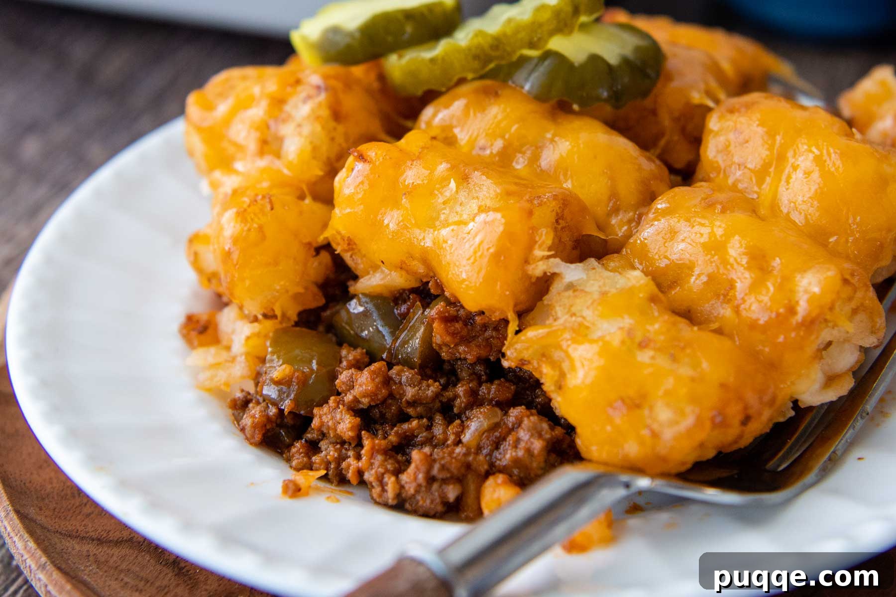 Golden Tater Tot Sloppy Joe Bake 9 A close-up view of a perfectly baked serving of Sloppy Joe Tater Tot Casserole, showcasing the texture of the crispy tots, melted cheese, and rich meat sauce.