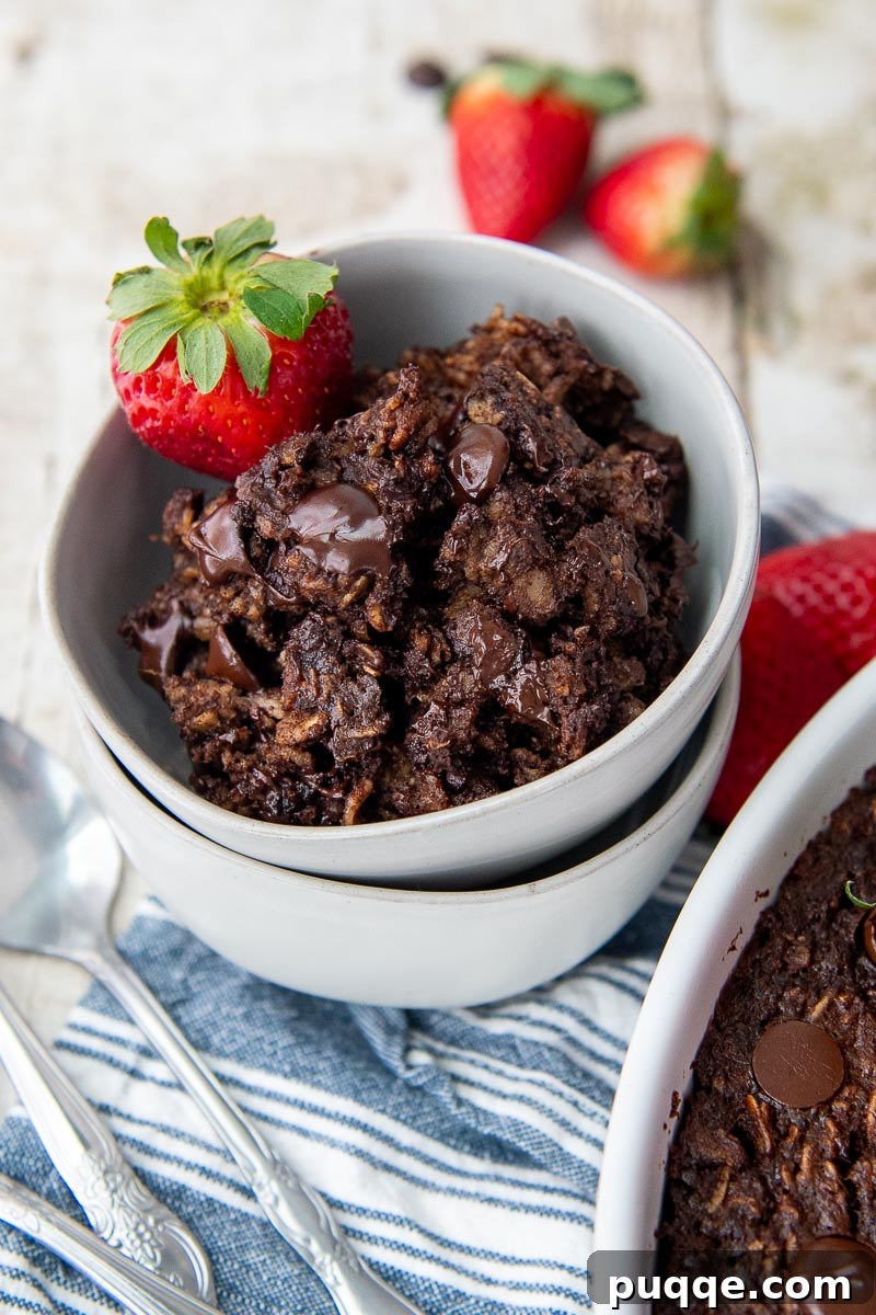 A double-stacked bowl of fudgy baked chocolate oatmeal, resting on a blue striped towel.