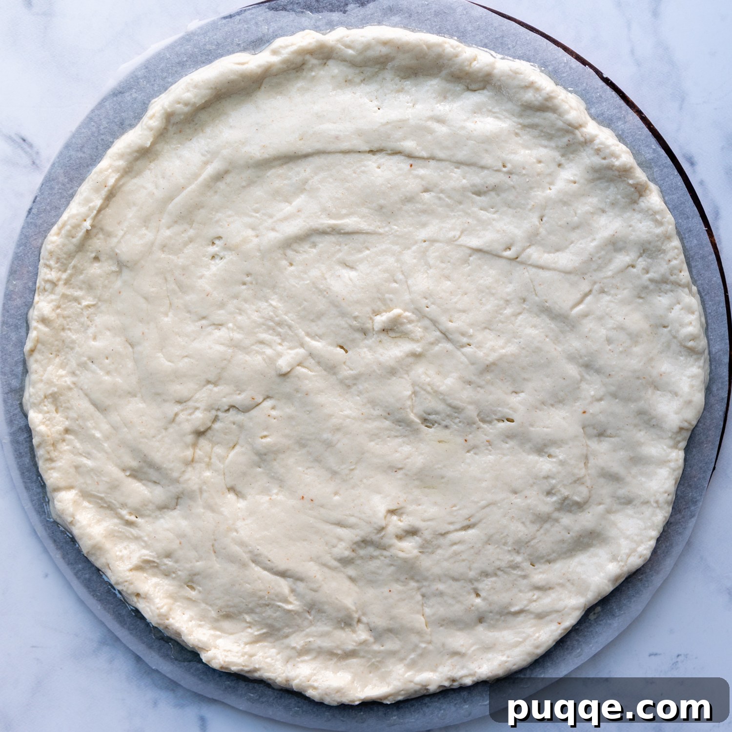 Perfectly Crispy Chewy No Knead Gluten-Free Pizza Crust 6 the dough spread out on a piece of parchment.