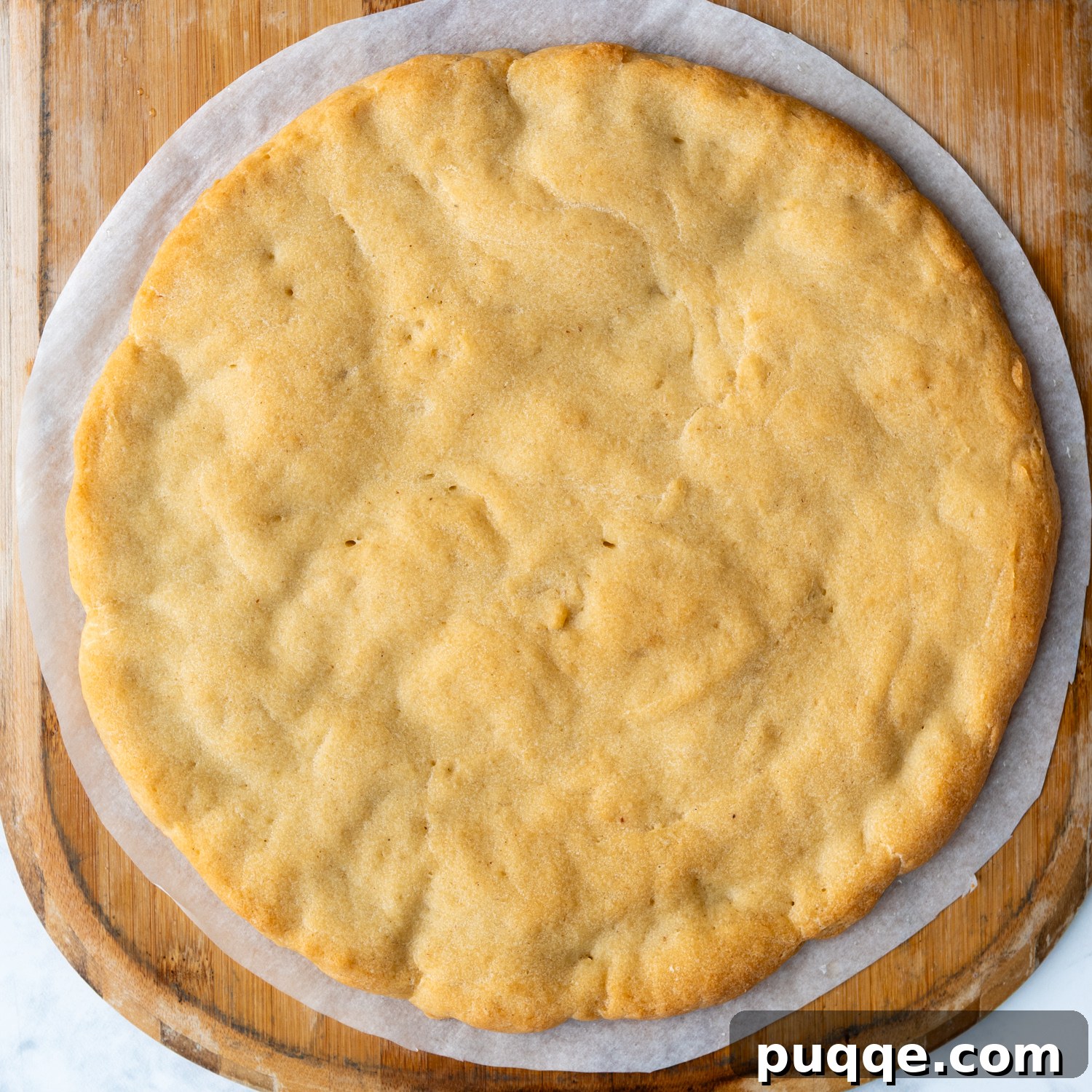 Perfectly Crispy Chewy No Knead Gluten-Free Pizza Crust 7 baked crust on a pizza paddle.