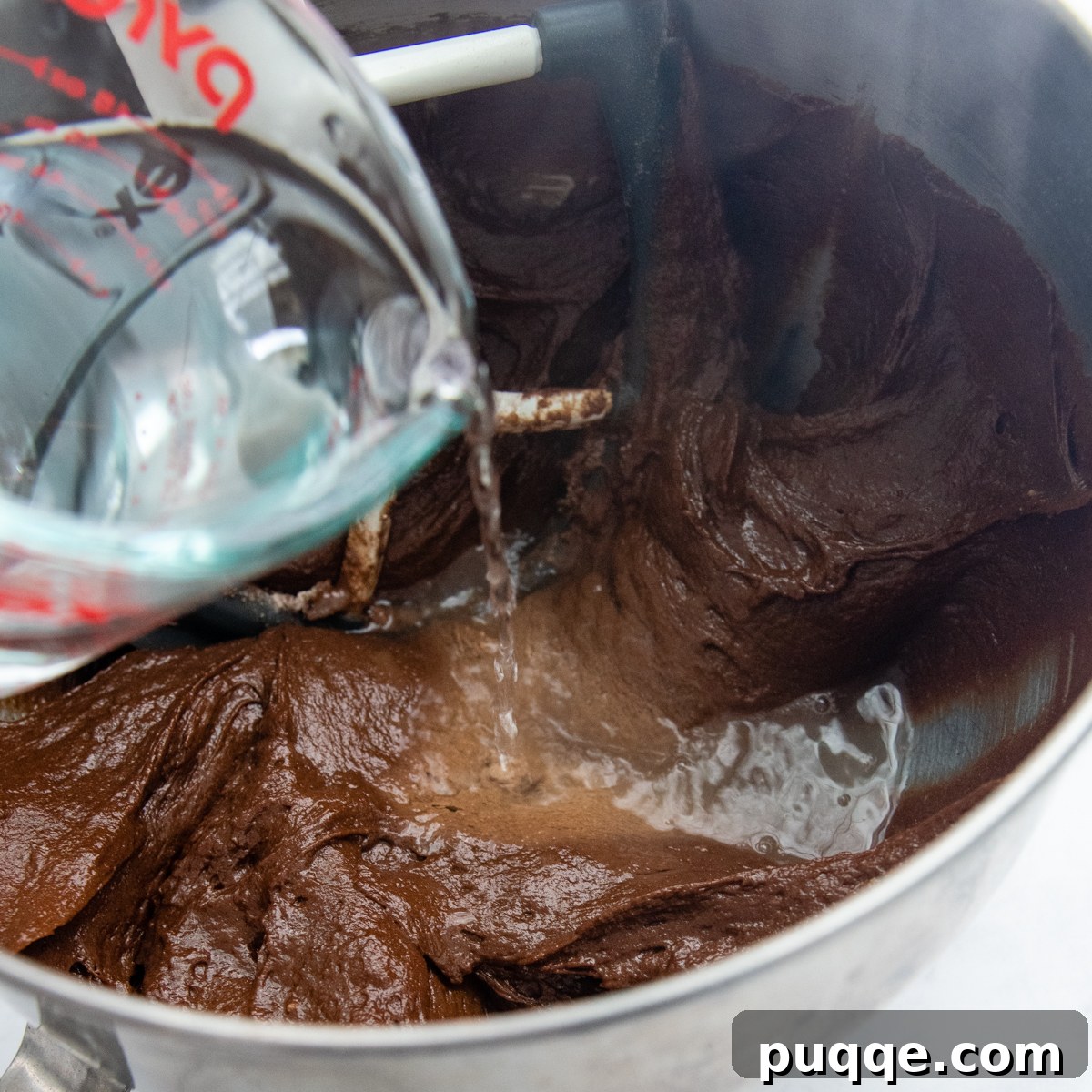 Grandma's Easy Gluten-Free Whoopie Pies 3 Boiling water being carefully poured into a mixing bowl containing the chocolate whoopie pie batter, creating a smooth mixture.