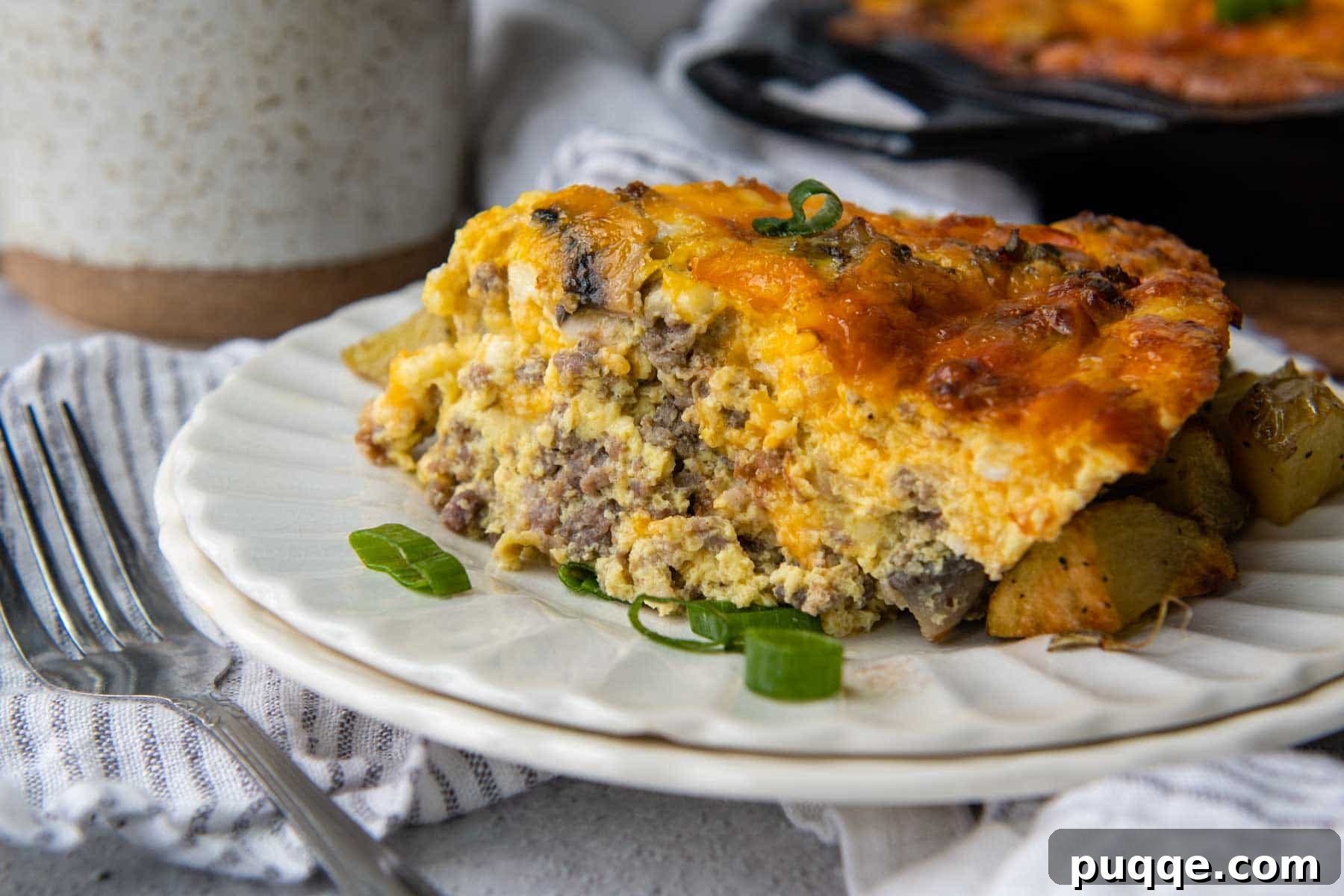 A perfectly portioned slice of crustless quiche on a white plate, garnished with fresh green onions for a vibrant finish.