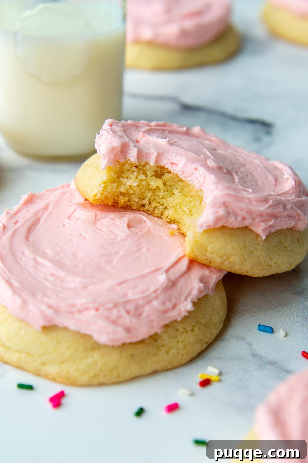 Ultimate Gluten-Free Crumbl Cookies 9 A delicious Crumbl-style cookie resting on top of another, with a tantalizing bite taken out of it to reveal its soft interior.