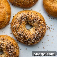 Effortless Soft & Chewy Gluten-Free Bagels 8 Overhead shot of gluten-free bagels on a white background, highlighting their perfect golden brown crust.