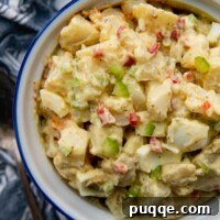 Wholesome Gluten-Free Amish Potato Salad 7 overhead shot of potato salad in a white bowl with a blue linen next to it.