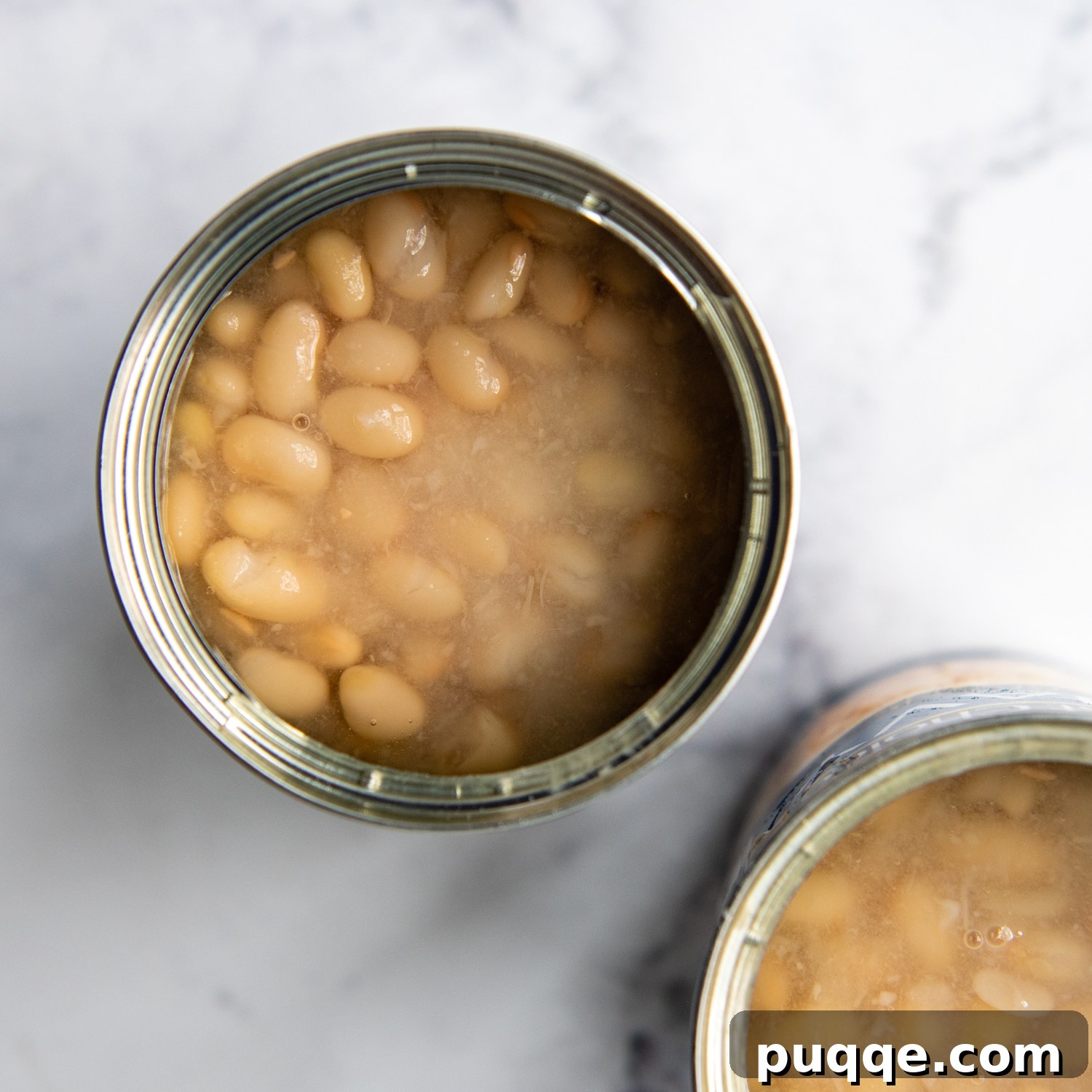 Ultimate Gluten Free Baked Beans 6 An open can of navy beans, partially drained, illustrating the ideal amount of liquid to retain for the baked bean recipe.