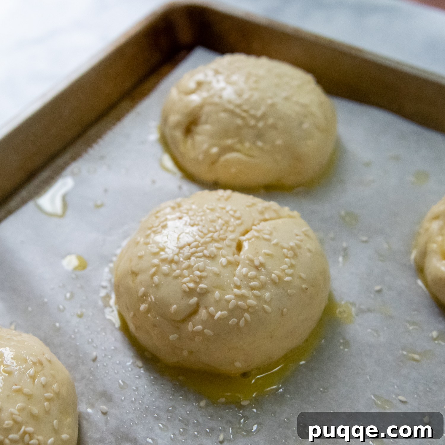 Unbelievably Soft Gluten Free Hamburger Buns No Crumbs 7 Freshly risen hamburger buns, brushed with an egg wash, awaiting their bake in the oven.