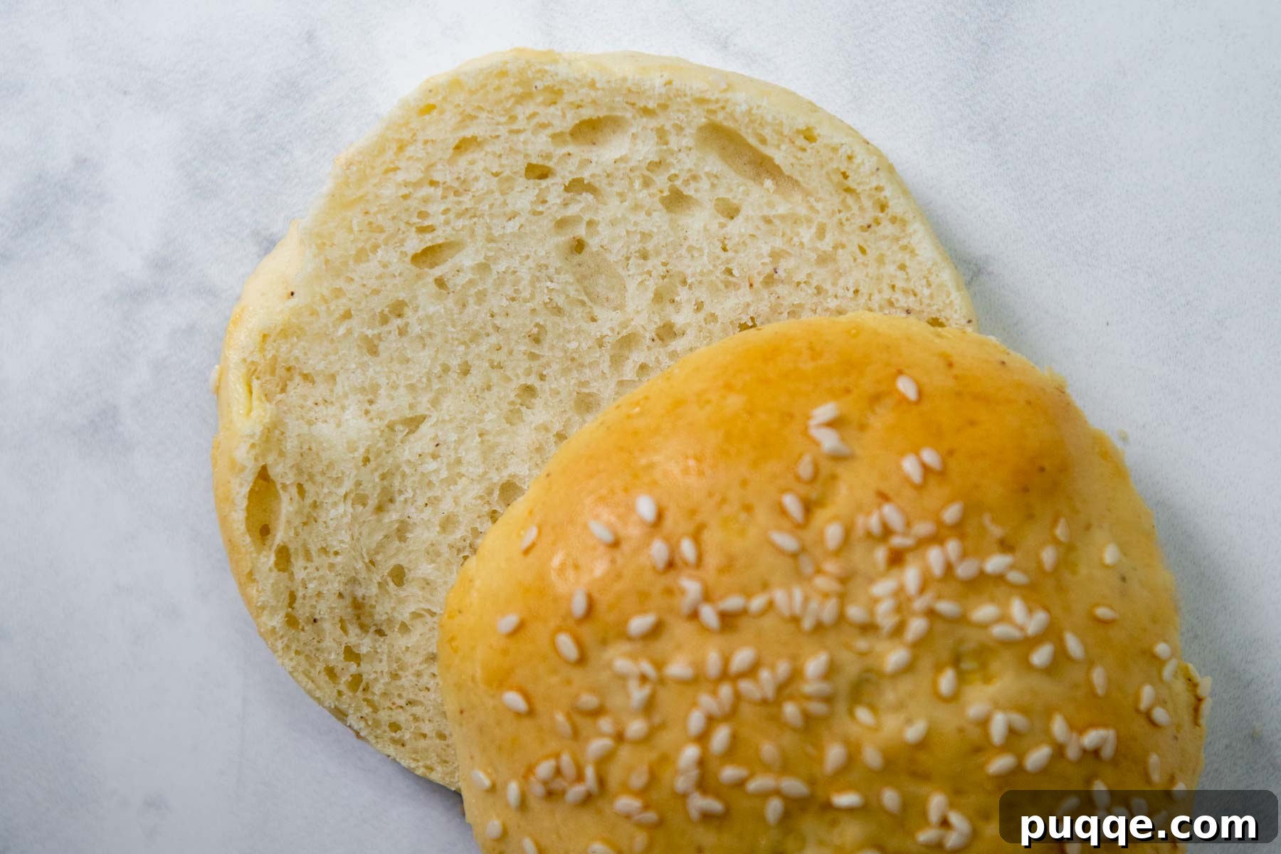 Unbelievably Soft Gluten Free Hamburger Buns No Crumbs 9 A perfectly baked, cut-open gluten-free hamburger bun, showcasing its soft, airy interior texture.
