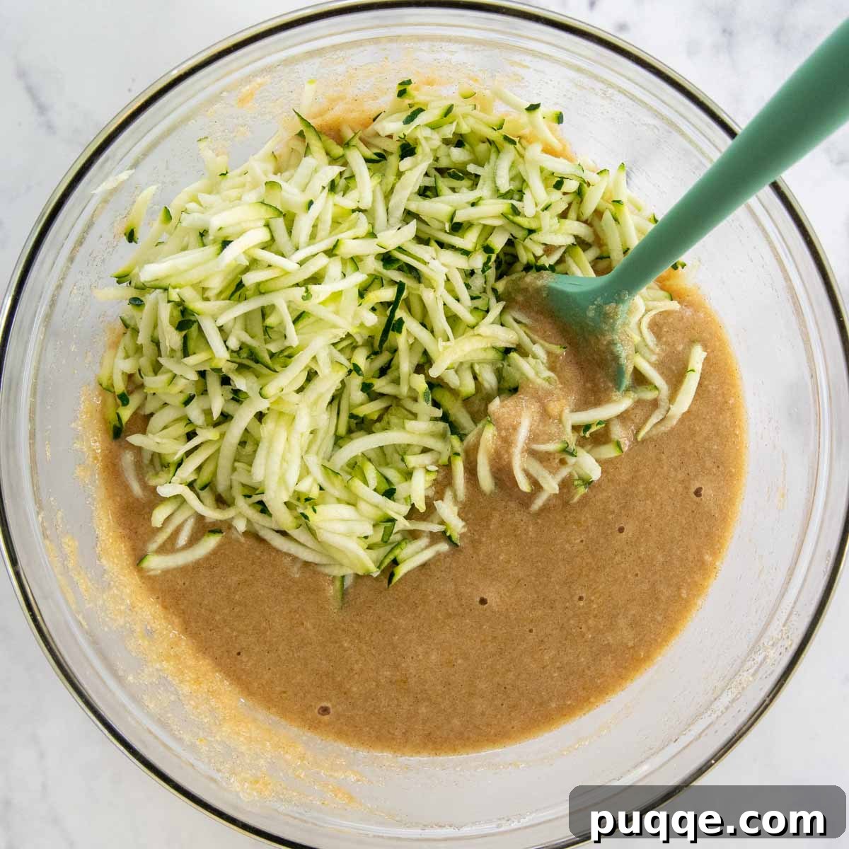 Muffin batter with grated zucchini mixed in, ready for baking.