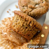 An almond flour zucchini muffin with the paper wrapping taken off, ready to be eaten.