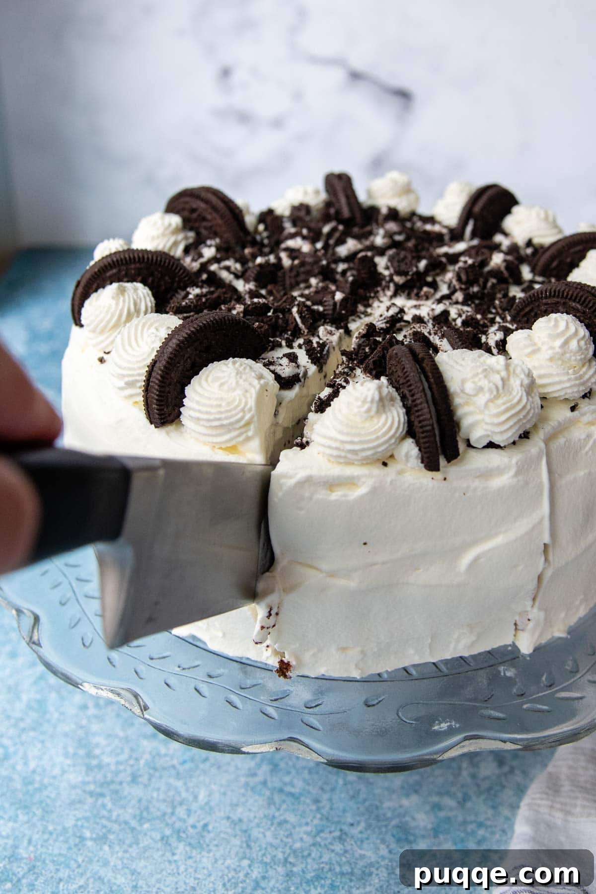 A large, sharp chef's knife effortlessly slicing through a vibrant ice cream cake, showing a clean, precise cut.