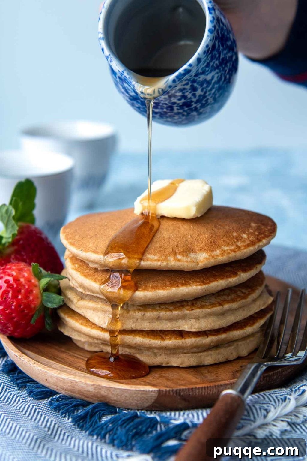 The Ultimate Gluten-Free Syrup Handbook: Top Brands and Effortless Homemade Recipes 3 Rich, golden syrup being poured generously onto a stack of uncut, fluffy flourless pancakes.