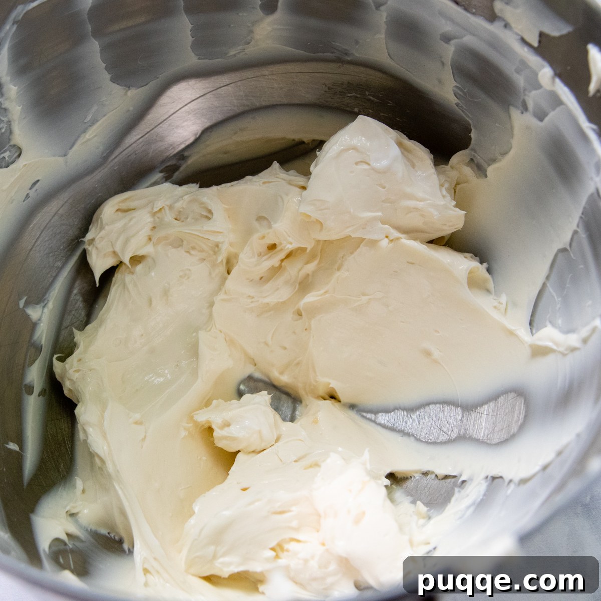 Quick Dreamy Gluten Free No Bake Cheesecake 4 A large stainless steel bowl filled with the creamy, smooth cheesecake base mixture.