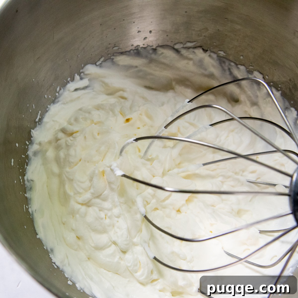 Quick Dreamy Gluten Free No Bake Cheesecake 5 Heavy cream being beaten to stiff peaks in a separate bowl, ready to be folded into the cheesecake filling.