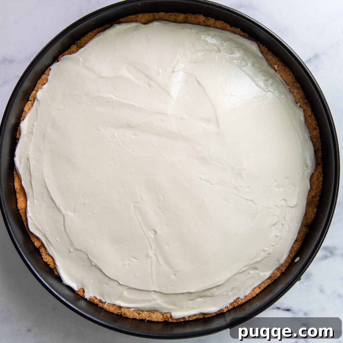 Quick Dreamy Gluten Free No Bake Cheesecake 6 The smooth, creamy cheesecake filling spread evenly into the baked almond flour crust, ready for chilling.