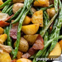 Close up of a serving of sheet pan roasted green beans, potatoes, and bacon.