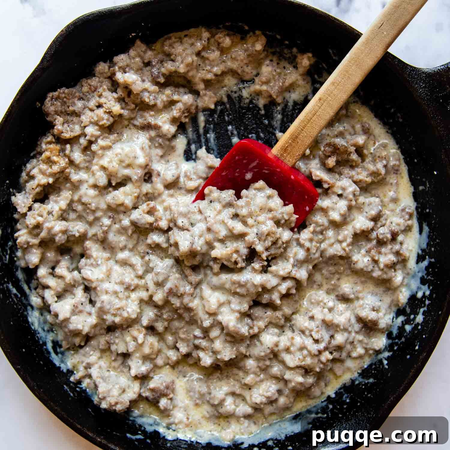 Effortless 10-Minute Gluten-Free Sausage Gravy 5 Sausage gravy with a slightly thinner, pourable white sauce, showing the ideal final consistency.