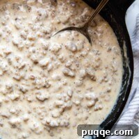 overhead shot of sausage gravy in a cast iron skillet.