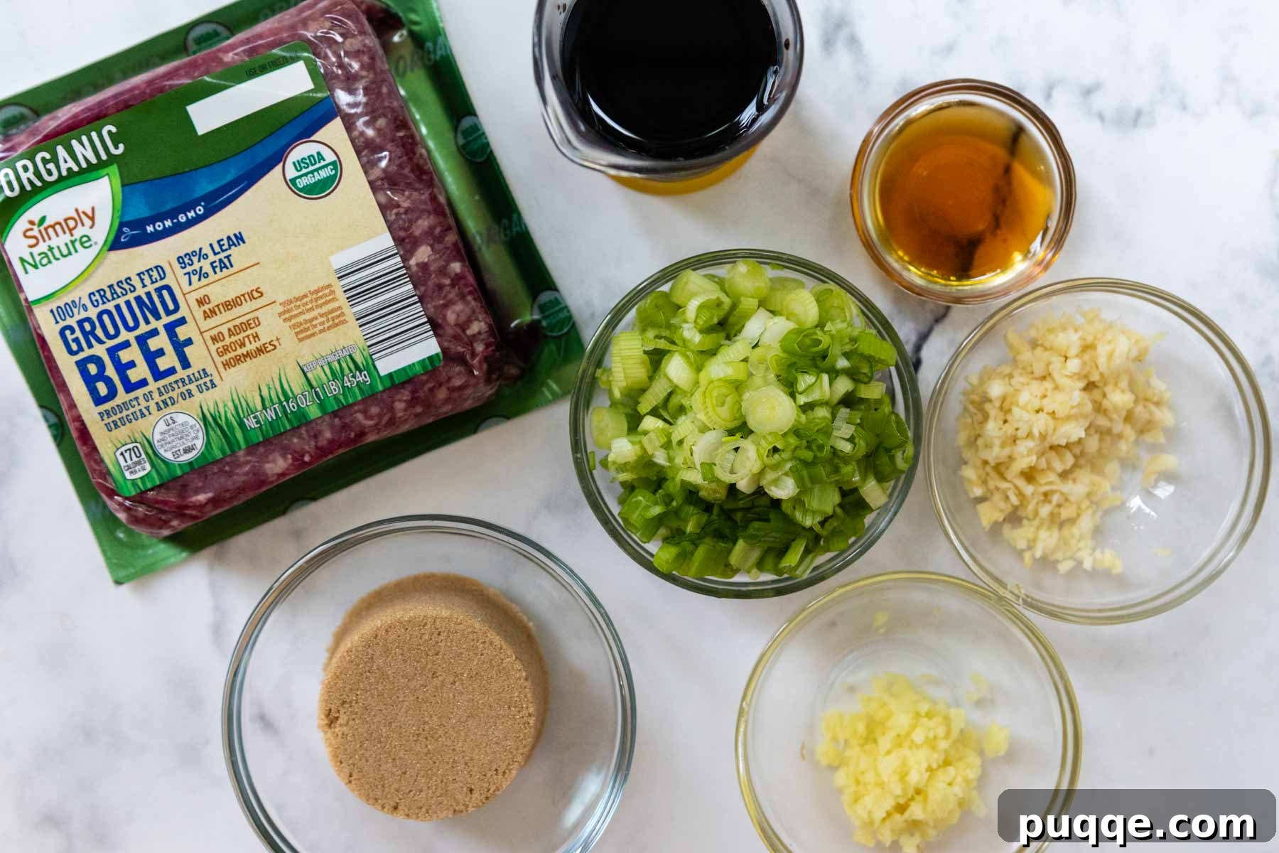 Flavorful Gluten-Free Korean Ground Beef Bulgogi 3 ingredients laid out on a cutting board, ready to make ground beef bulgogi, showing fresh ginger, garlic, green onions, and soy sauce.