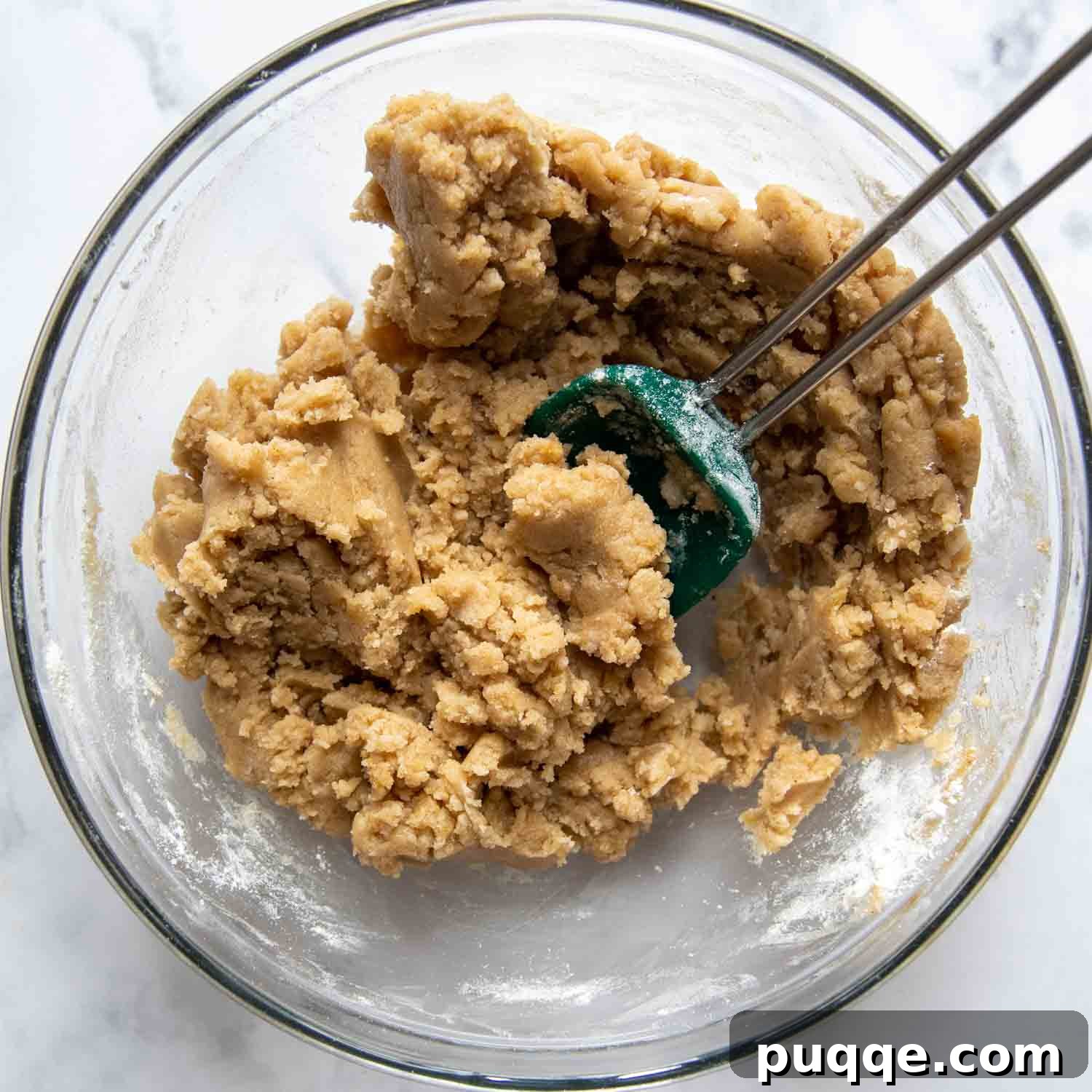 The oat-free crisp topping mixture in a glass bowl, being stirred to combine all ingredients.