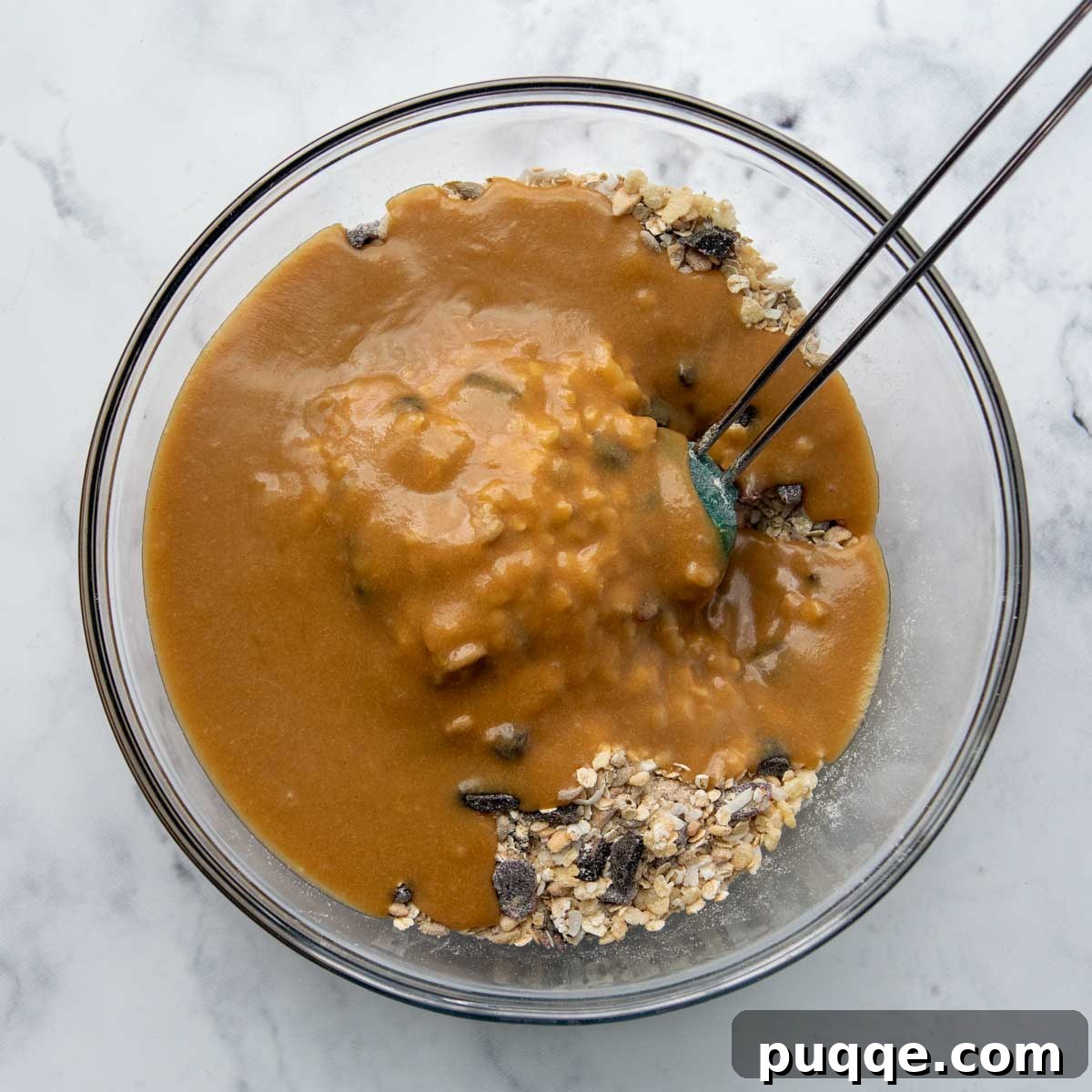 Ultimate Chewy Gluten-Free Chocolate Chip Granola Bars 5 The wet mixture being poured over the dry ingredients and stirred to combine.