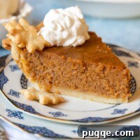 Southern Soul Gluten-Free Sweet Potato Pie with a Flaky Golden Crust 10 a slice of pie on a plate with whipped cream on top and the whole pie in the background.