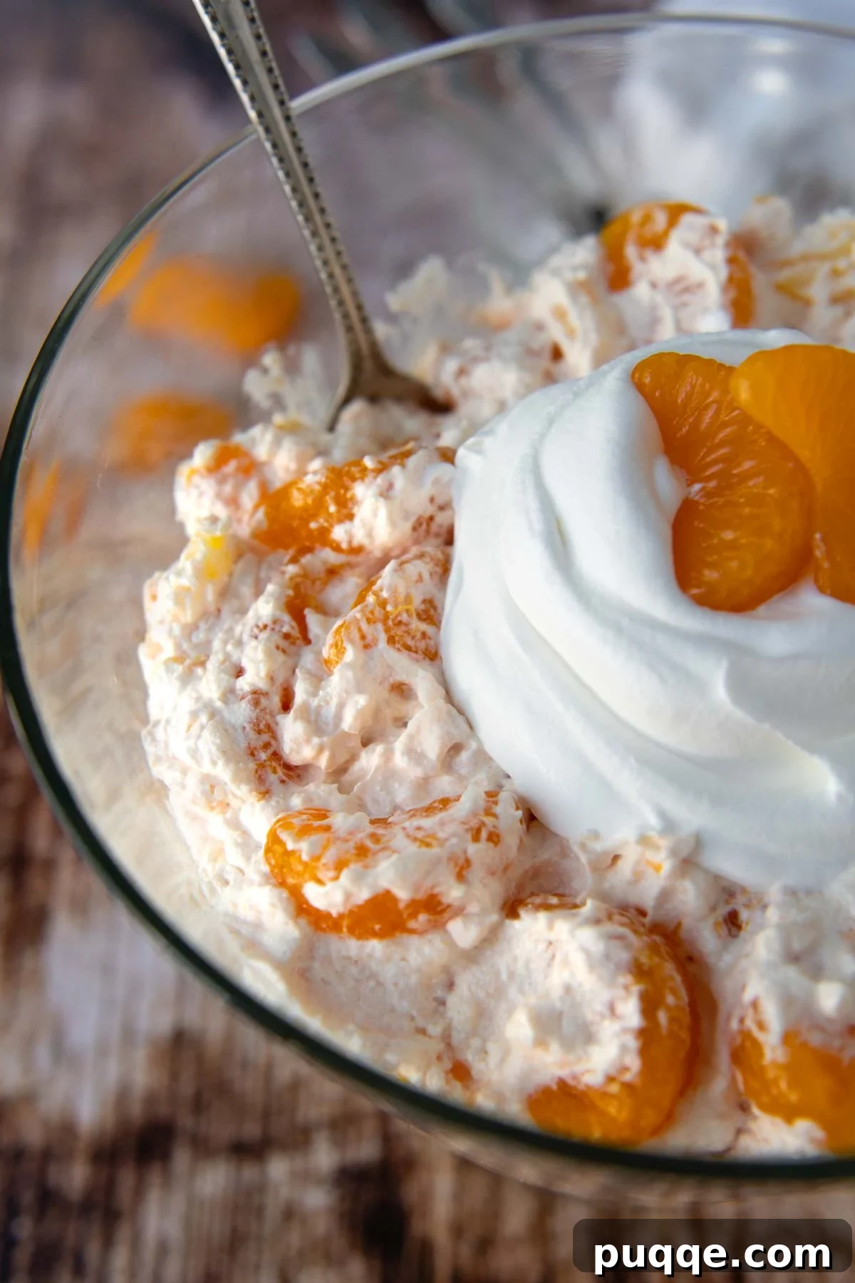Close-up of the fluffy top of an orange fluff salad, garnished with whipped cream, ready to serve.