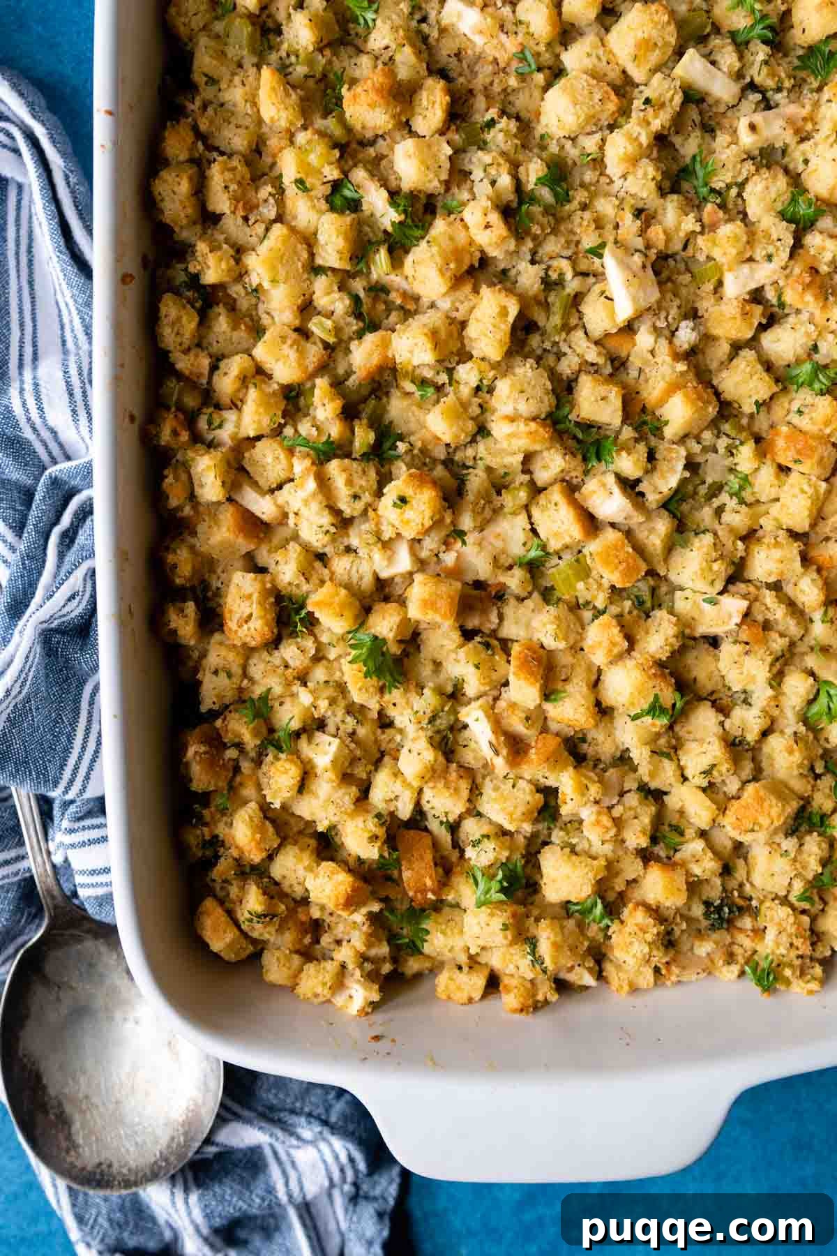 Overhead shot of moist gluten-free bread stuffing with apples in a white baking dish, ready to be served.