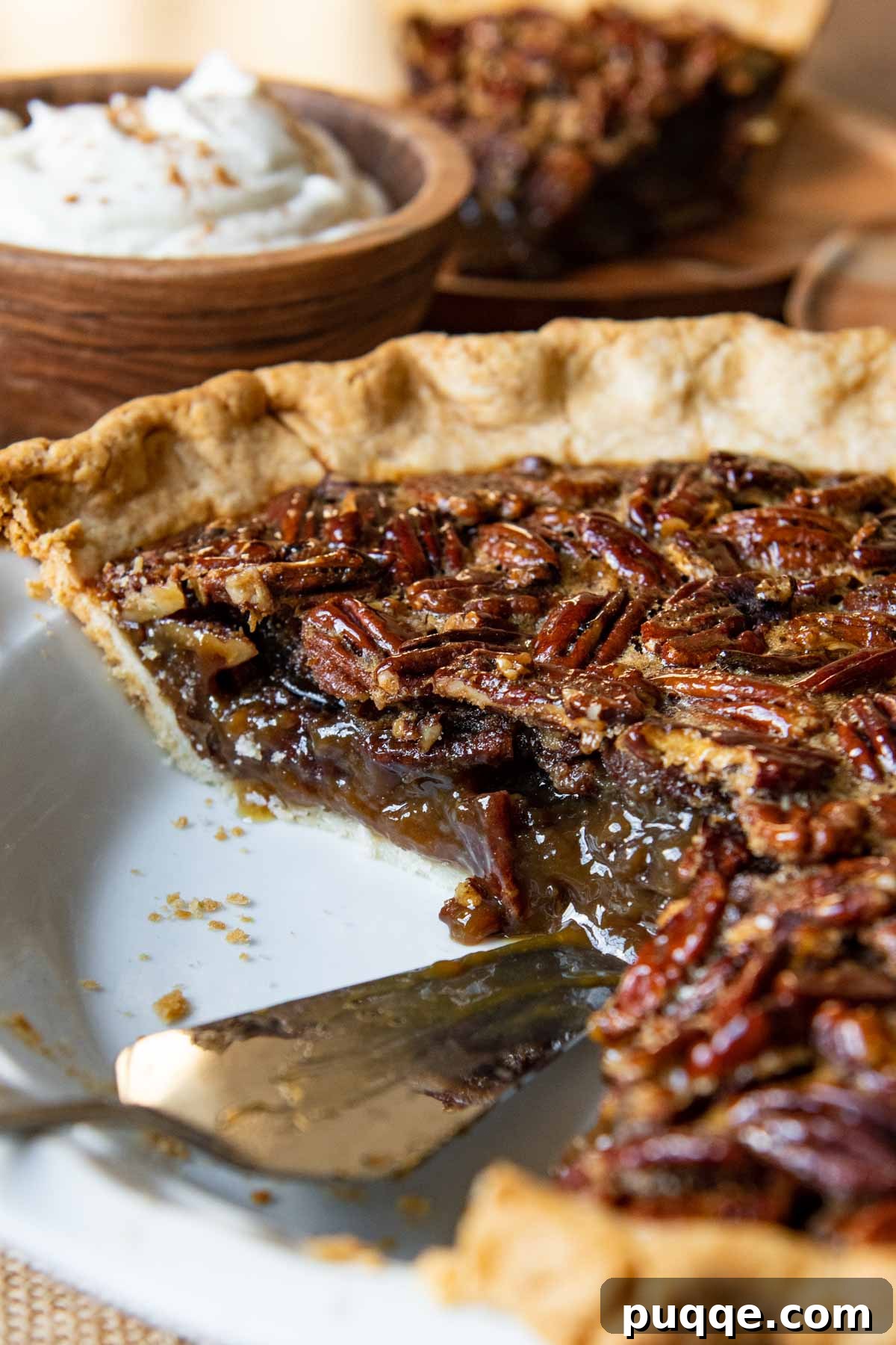 A close-up of a perfectly sliced gluten-free pecan pie, revealing its rich, gooey filling and golden crust.