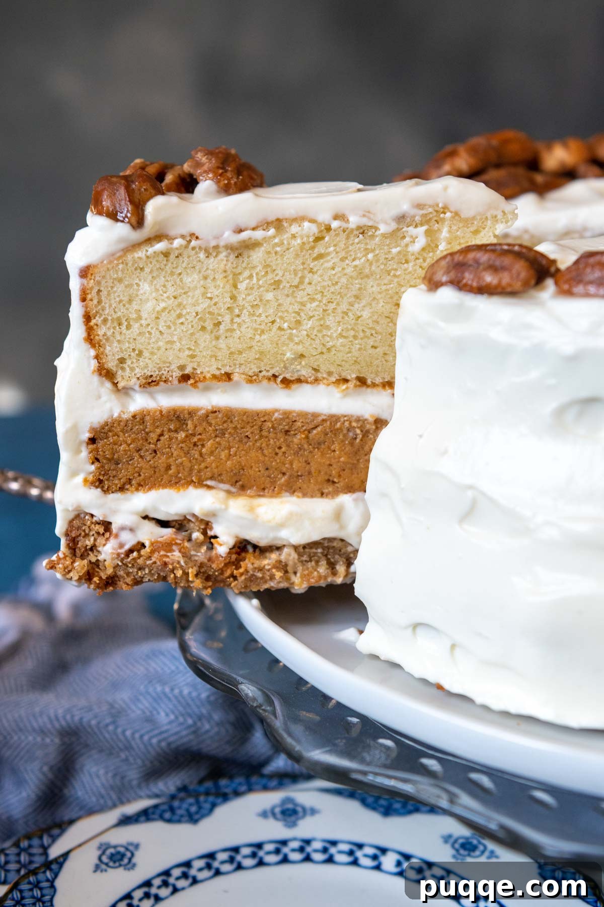 A delectable slice of pumpkin pie layer cake, also known as Piecaken, being served from a cake platter, revealing its intricate layers.
