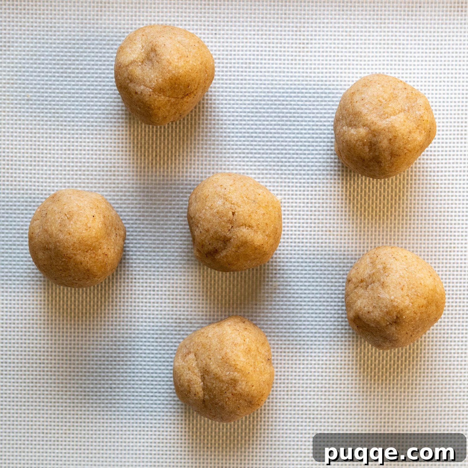 Six evenly sized dough balls shaped and ready for rolling.