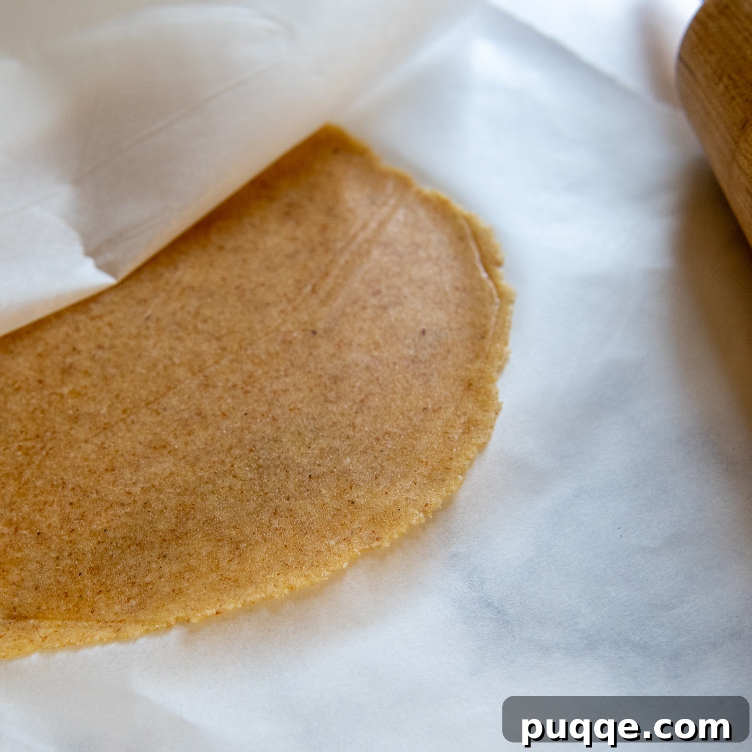 The rolled almond tortilla, showcasing its ideal thinness after being shaped and excess dough removed.